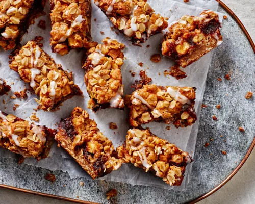 Apple Date Crumble Bars served on a piece of folded parchment on a blue tray